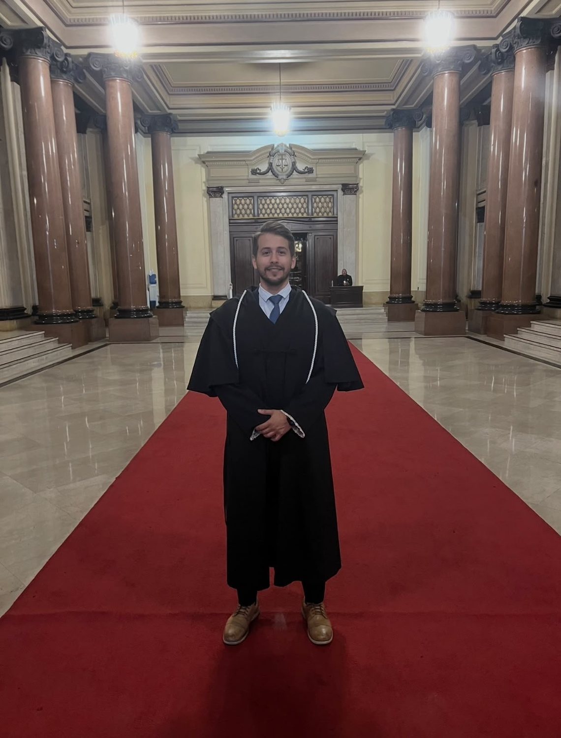 Erik Piva de beca no saguão do tribunal